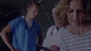 Tıbbi ekip panoyu incelerken anne gülümseyen çocuğu rahatlatıyor. Sağlık, profesyonellik, takım çalışması, danışma, teşhis, şefkat, klinik