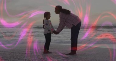 Anne, zihinsel sağlığı kutlamak için etrafında dönen girdaplarla kızını öpüyor. Aileler, bağlantılar, dinginlik, alacakaranlık, uyum, şefkat, maneviyat