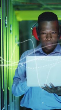 Animation of data processing over african american male it engineer and computer servers. Global computing and data processing concept digitally generated video.