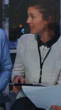 Animation of data processing and cityscape over diverse business people at office. Global business, finances and digital interface concept digitally generated video.