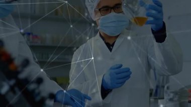 Laboratuar ekibi tablet verilerini inceliyor ve ağ örtüsü altında kehribar şişesini inceliyor. Netlik değerlendirmesi yapıyor. Bilim, yenilik, araştırma, teknoloji, işbirliği, analiz, deney