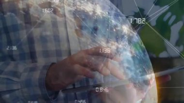 Teknolojik erkek dinleme tableti dönen dünyayı etkinleştiriyor küresel verileri birleştiriyor ve akıllı telefonu arıyor. Teknoloji, veri görselleştirme, yenilik, dijital, bağlantı, iş dünyası, modern