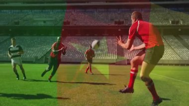 Kırmızı oyuncu ragbi topunu pas atarken, tutucu defans vuruşundan önce topu yakalıyor. Sporcular, takım çalışması, çeviklik, rekabet, açık hava, dayanıklılık, strateji