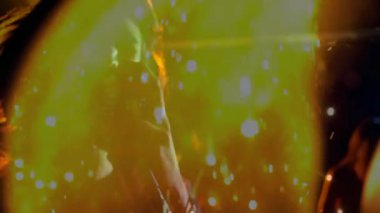 VFX setiyle soldan bir kadın giriyor, silueti alev perdesi ve parlayan kıvılcımlardan vurguluyor. Ateş, gösteri, aydınlatma, hareket, ambiyans, kontrast, dramatik