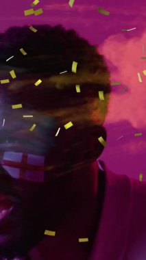 Afro-Amerikan erkek destekçisi ve İngiltere bayrakları üzerinde konfeti animasyonu. Spor ve dijital arayüz konsepti dijital olarak oluşturulmuş video.