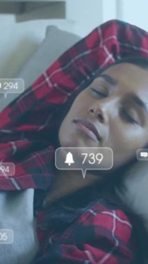 Medya ikonlarının kanepede uyuyan kadın üzerindeki canlandırması. Sosyal medya ve dijital arayüz konsepti dijital olarak oluşturulmuş video.