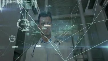 Doktor tableti tutarken aşağıya bakıyor ve gözden geçirmek için holografik veri ağı oluşturuyor. Tıbbi, teknoloji, yenilik, fütüristik, araştırma, veri, analiz