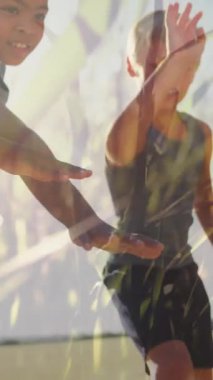 Açık hava spor sınıfında el ele tutuşan mutlu okul çocukları üzerinde güneş ve çimenlerin canlandırması. Okul, eğitim, sağlık, çocukluk ve öğrenme, dijital olarak oluşturulan video.