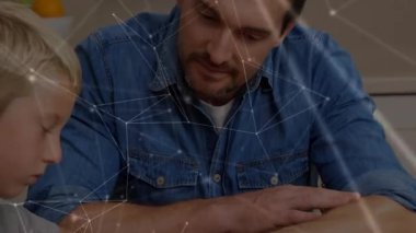 Baba, eğitim için tahta masada oğlunun yazılarını mavi kalemle okuduğuna işaret ediyor. Ebeveynlik, eğitim, aile, öğrenme, akıl hocalığı, sınıf, iletişim