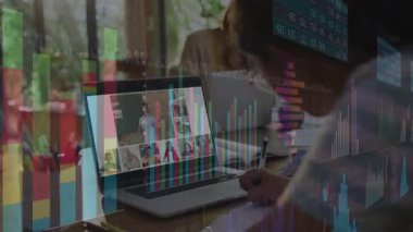 Kalem seçen ve online finans dersinde not alan adam dizüstü bilgisayardaki dosyaları güncelliyor. Eğitim, uzaktan öğrenme, dijital sınıf, üretkenlik, yenilik, işbirliği, meslek