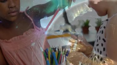 El sanatları masasında renkli kalemleri sınıflandıran kızlar okul projesi için dönen galaksi örtüsüne neden oluyorlar. Çocuklar, yaratıcılık, işbirliği, yaratıcı, canlı, eğitici, renkli