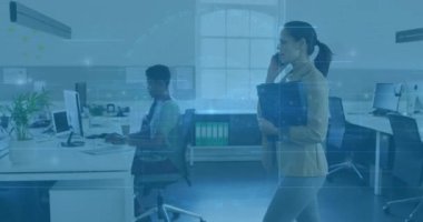 Ofise giren klasörleri taşıyan profesyonel bir kadın telefon ederken, iş arkadaşı bavulu yuvarlıyor. İş yeri, işbirliği, modern, minimalist, teknoloji, üretkenlik, iş dünyası