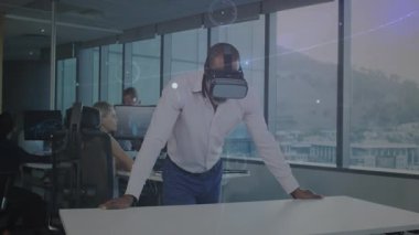 Erkek, VR kulaklık takıyor ve masaya yaslanıyor. İş ofisindeki animasyon veri ağını yansıtıyor. Teknoloji, yenilik, işbirliği, dijital, fütüristik, üretkenlik, çalışma alanı