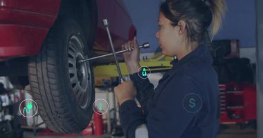 Kadın teknisyen bijon anahtarı ve gevşeten tekerlek fındıkları ile oto tamirhanesinde ekolojik ikonlar sürükleniyor. Mekanik, bakım, yenilik, sanayi, takım çalışması, verimlilik, araçlar
