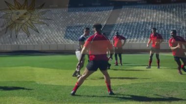 Rugby antrenmanı sırasında kırmızı defans oyuncusuyla karşılaşan mavi çizgili bir oyuncu. Sporcular, spor sahası, dinamik, takım çalışması, rekabet, açık hava, aksiyon