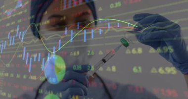 Hemşire aşı şişesini açıp aşı için doz alırken finansal tabloları izliyor. Tıbbi, sağlık, finans, analiz, teknoloji, profesyonellik, kesinlik
