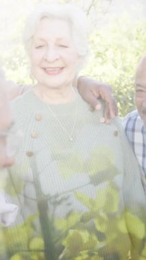 Bahçede gülümseyen yaşlı insanlar üzerinde ağaçların animasyonu. Mutluluk, kıdemli yaşam tarzı, aktif yaşam tarzı ve dijital olarak oluşturulmuş emeklilik konsepti.