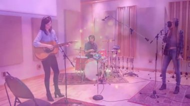 Stüdyo arkadaşları tıngırdıyor, davul çalıyor, şarkı söyleyen mikrofon, pembe-mor parçacıklar yoğun bir şekilde yayılıyor. Müzisyenler, canlı performans, ses mühendisliği, canlı, enerjik, yaratıcı ortam, dinamik