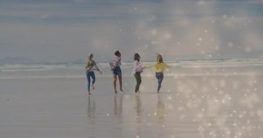 Seyahat videosunda arkadaşların dönen, ıslak kumda el ele tutuşan ve sonra kıvılcımlar saçarak koştuğu görülüyor. Arkadaşlık, dostluk, boş zaman, açık hava, canlı, neşeli, hareketli