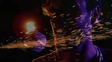 Sol kenardan kıvılcımlar çıkıyor ve mikrofonda erkek şarkıcı çene hattını silip süpürüyor. Performans, sahne, dramatik, enerjik, aydınlatma, gösteri, müzik