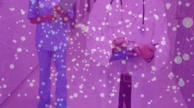 Erkek doktor hastane koridoruna girip panoya yazı yazarken hemşire çizelgeyi takip ediyor. Tıbbi, sağlık, profesyonellik, işbirliği, klinik, tanı, belgeleme