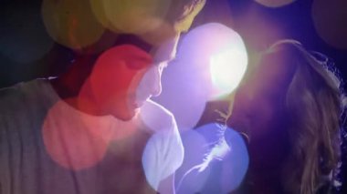 Kadın mikrofona eğiliyor ve müzik düetine başlıyor, erkek de bokeh ışıkları altında şarkı söylemeye karşılık veriyor. Performans, düet, sahne, ışıklandırma, uyum, spot ışığı, işbirliği