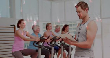 Kod kaplaması başlatılırken, eğitmen panoyu gözden geçirir, fitness sınıfında bisikletçilere rehberlik eder. Fitness, training, cardio, digital, technology, motivasyon, wellness