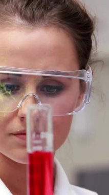 Kafkas kadının sıvı dolu test tüpünü sallarken yakın plan DNA sarmalının animasyonu. Dijital bileşik, çoklu maruz kalma, molekül, anatomi, tıbbi, sağlık ve teknoloji konsepti.