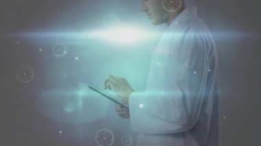 Doktor tableti tıklatıyor ve tıbbi teşhisler için holografik ağ oluşturuyor. Gelecek, teknoloji, yenilik, sağlık, dijital, bilim, bağlantı