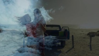 Bulutların altında sigara içen, sörf tahtası kapıp dans eden çift. Romantizm, plaj, eğlence, açık hava, oyuncu, bağlantı, manzara