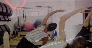 Pilates hocası rehber sınıfı kırmızı çizelge altında geriliyor sonra yayları ayarlıyor ve gülümsüyor. Fitness, esneklik, sağlık, iç mekan, öğretici, denge, sağlık