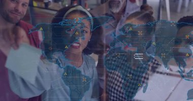 Ekip, harita çalışması için cam panoya kart yerleştiriyor ve dünya haritası bağlantıları kuruyor. İşbirliği, strateji, yenilik, takım çalışması, dijital, veri görselleştirme, kurumsal