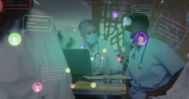 Toplantı odasında sohbet baloncuklu dizüstü bilgisayar kullanarak önlük ve maske takarak toplantı yapmak. Sağlık, işbirliği, dijital, profesyonellik, iletişim, takım çalışması, modern