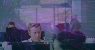 Modern ofis ekibi iş yerlerindeki monitörleri inceliyor, mor ışık üstüste biniyor. İşbirliği, takım çalışması, yenilik, veri görselleştirme, dijital ortam, profesyonel, modern