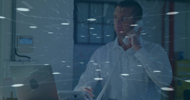 Telefon kablosu var, beyaz gömlekli adam ofisteki masada dizüstü bilgisayara bakıyor, ışık çizgileri var. Profesyonel, iletişim, modern, çalışma alanı, şirket, teknoloji, üretkenlik