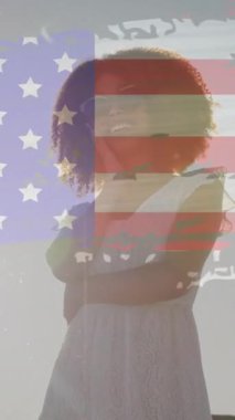Sahilde eğlenen Afrikalı Amerikalı kadınlara karşı Amerikan bayrağının animasyonu. Bağımsızlık Günü kutlaması ve tatil konsepti