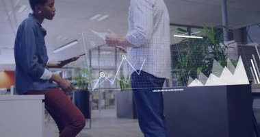 Sayfaları çeviren adam, iş haritalarının dünya haritasına kaymasına, kadının tabletteki verileri incelemesine neden oluyor. İşbirliği, analiz, veri görselleştirme, profesyonel, takım çalışması, dijital, modern