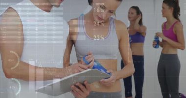 Jimnastik sınıfındaki stajyerin yanındaki panoya tıklayarak rehberlik için animasyon çizelgelerini aktifleştiriyor. Koçluk, takım çalışması, motivasyon, sağlık, ilerleme, fitness, sağlıklı yaşam tarzı