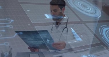 Hekim, holografik tıbbi çizelgelerin ortasında incelemek ve ortalamak için röntgen filmini masadan kaldırıyor. Tıbbi, teknoloji, fütüristik, tanı, artırılmış gerçeklik, sağlık, analiz