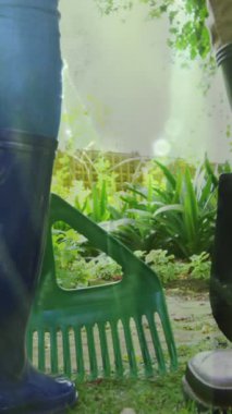 Bahçede çalışan lastik çizme giyen iki kişinin bacaklarının üzerinde çimen canlandırması. Küresel ekoloji, yaşam tarzı ve doğa konsepti dijital olarak oluşturulmuş video.