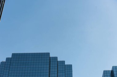 Low angle view of office building against blue sky