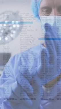 Yüz maskeli beyaz erkek cerrah üzerinde veri işleme animasyonu. Teknoloji, tıp ve dijital arayüz kavramı dijital olarak oluşturulmuş video.