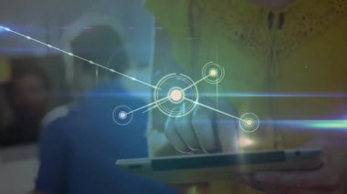Sarı gömlekli adam tableti tıklatıyor ve veri düğümünü başlatıyor ve teknoloji ağı görselleştirmesi yapıyor. Teknoloji, yenilik, bağlantı, dijital, arayüz, işbirliği, fütürist