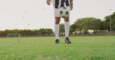 Düşük açılı çerçeveli bacaklar spor antrenmanı sırasında erkek futbolcuyu sahada hokkabazlık yapmaya başlatıyor. Atletik, dinamik, hareket, eğitim, aktif, açık hava, performans