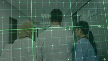 Tıbbi ekip yeşil ızgara altında hastane koridorunda yürüyor. Okuma odası tabelasını geçiyor. Sağlık, takım çalışması, profesyonellik, hastane, ulaşılabilirlik, dijital teknoloji, işbirliği