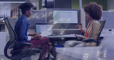 İki kadının şık kıyafetler giymesi, kahve fincanıyla el kol hareketi yapması, ofiste dizüstü bilgisayarda yazı yazması. İşbirliği, takım çalışması, modern, kurumsal, üretkenlik, iletişim, teknoloji