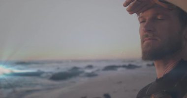 Seyahat pazarlamacısı, kayalık kıyı şeridinde kollarını kaldırarak kampanya için gün batımı ufkunu tarıyor. Yolculuk, macera, keşif, dinginlik, siluet, ufuk, tefekkür