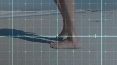 Islak kumda yürüyen bir kadın, mavi şebeke örtüsünü etkinleştiriyor, teknoloji çalışması için ayak izlerini takip ediyor. Sahil, kıyı şeridi, ayak izleri, dinginlik, minimalizm, dijital örtüşme, refah