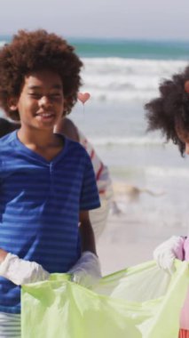 Afrika kökenli Amerikalı kadın ve erkek gönüllülerin sahildeki çöpleri toplaması üzerine kupa animasyonu. Çevre koruma gönüllüleri, plaj temizleme konsepti dijital olarak oluşturulmuş video.