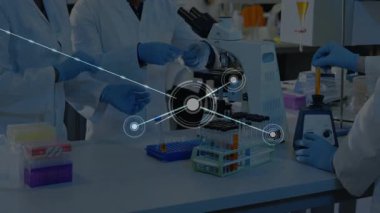 Laboratuvar araştırma ekibi pipetlerle örnekler çiziyor ve mikroskop kullanarak veri örtüsünü genişletiyor. Bilim, işbirliği, yenilik, teknoloji, kesinlik, analitik, takım çalışması